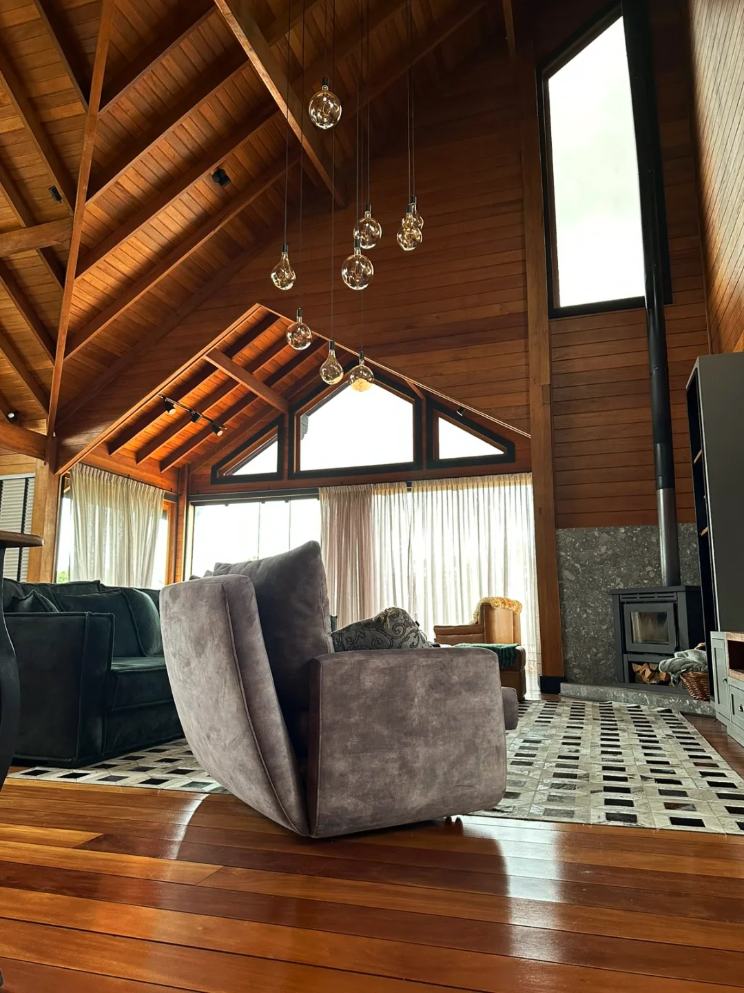 Interior com escada e janelas para a mata em casa de madeira de cliente